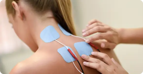 A patient receiving a non-invasive Softwave therapy treatment to stimulate tissue healing and reduce chronic pain in the neck and upper back.
